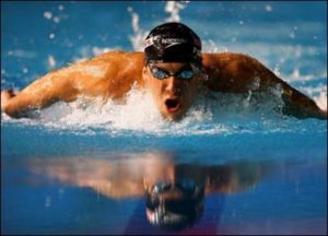 Michael Phelps in vlinderslag zonder zwempak.